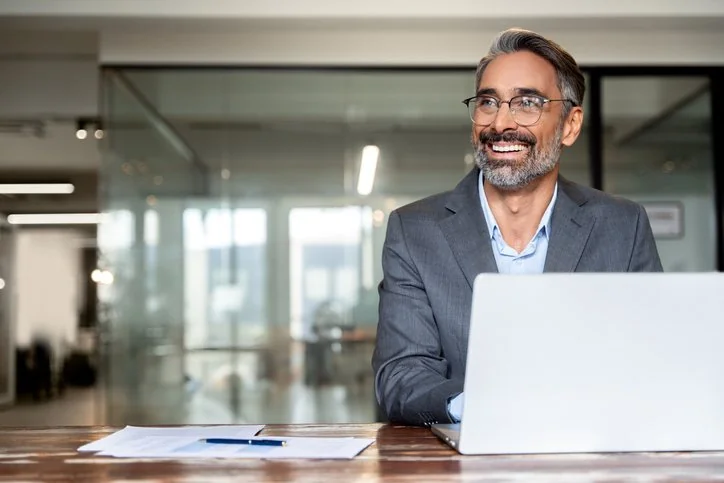 Immobilienexperte prüft Vertragsunterlagen am Laptop